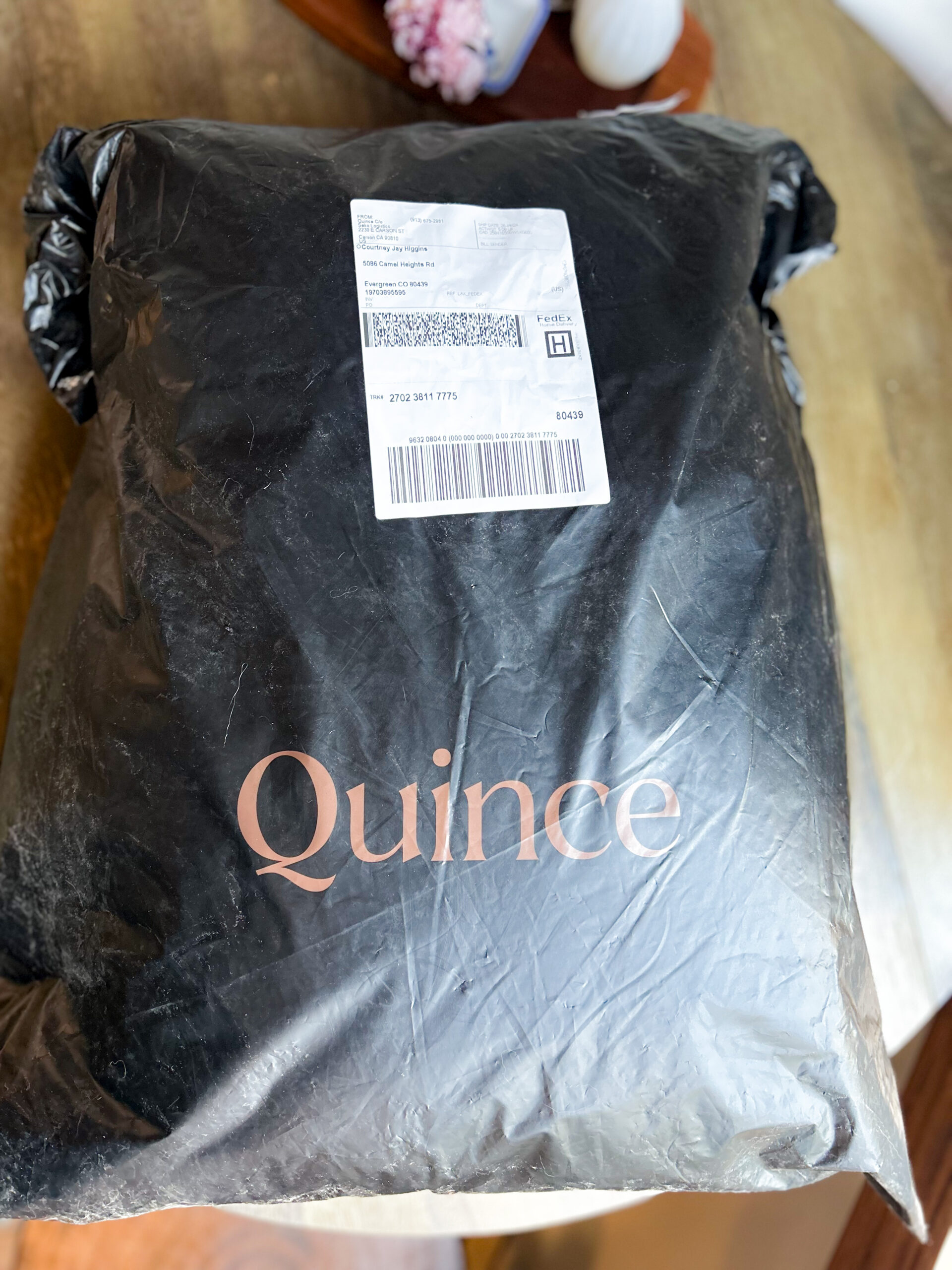 A bag with the word quince on it sitting on a table.