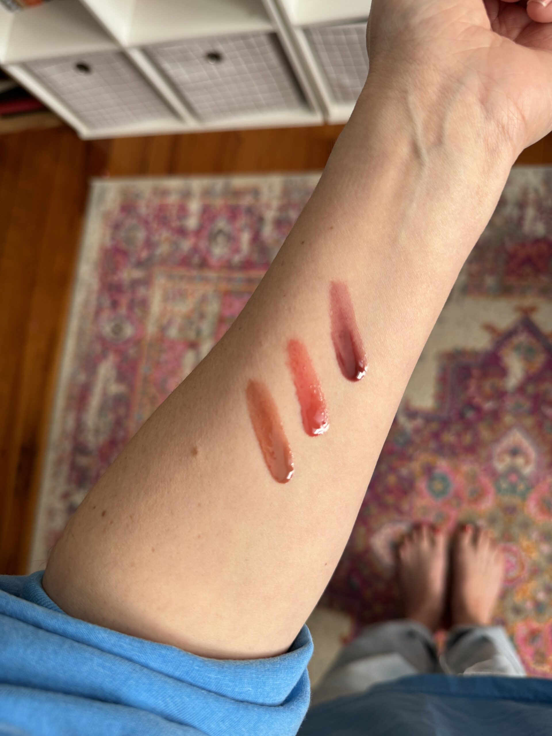 Three lipsticks on a person's arm.