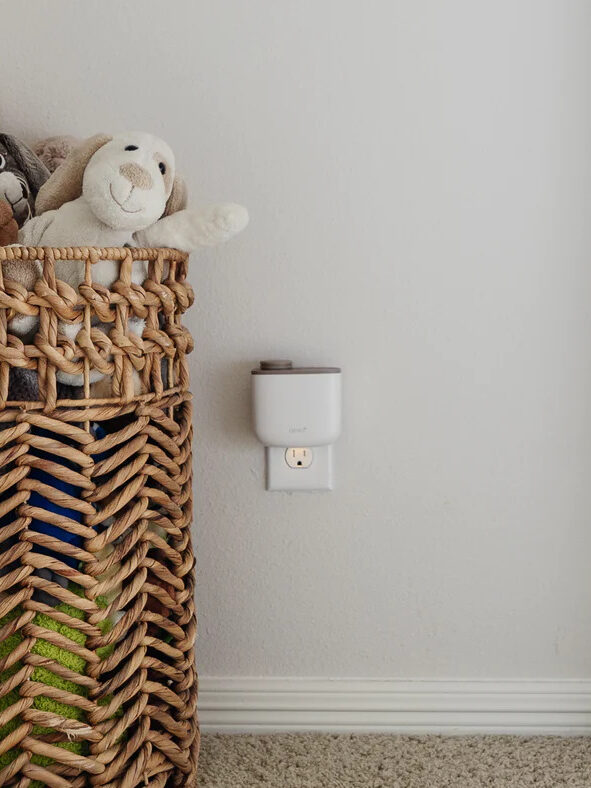 An Aera mini diffuser plugged into the wall of child's bedroom. 