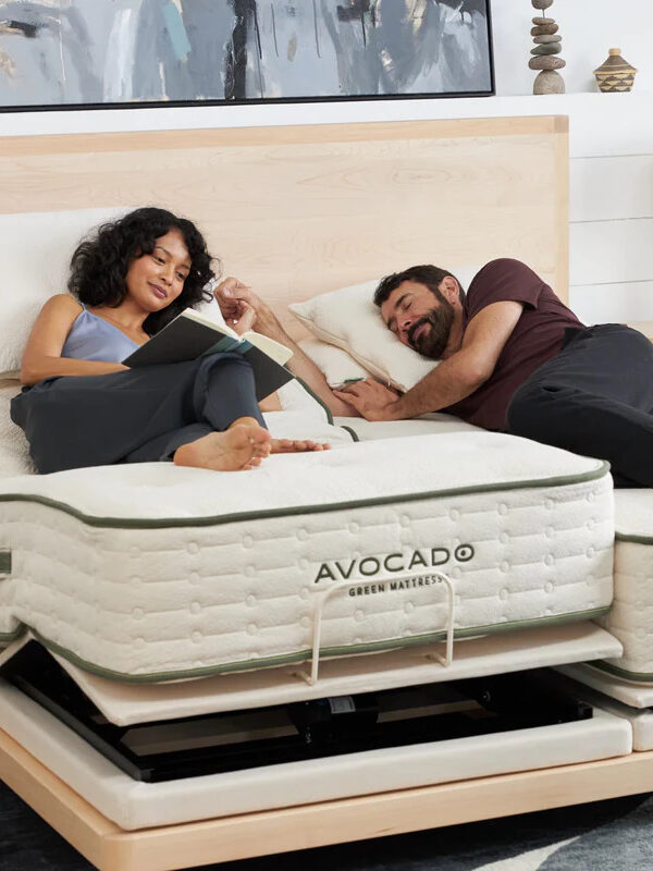 A man and woman laying on top of a mattress.
