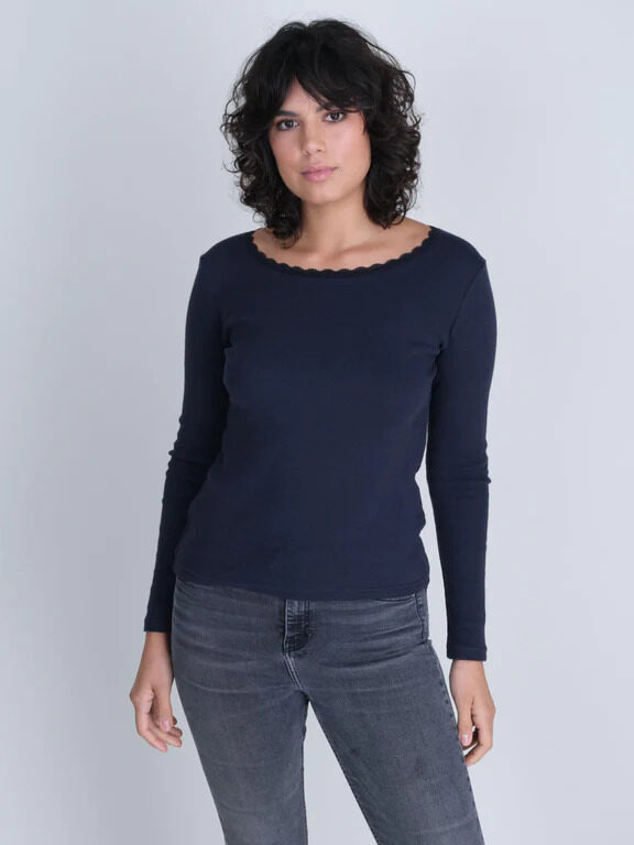 The model is wearing a navy long - sleeved top and jeans.