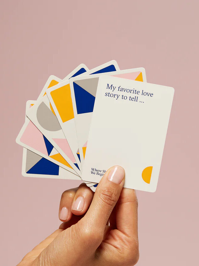 A hand holding a set of cards.