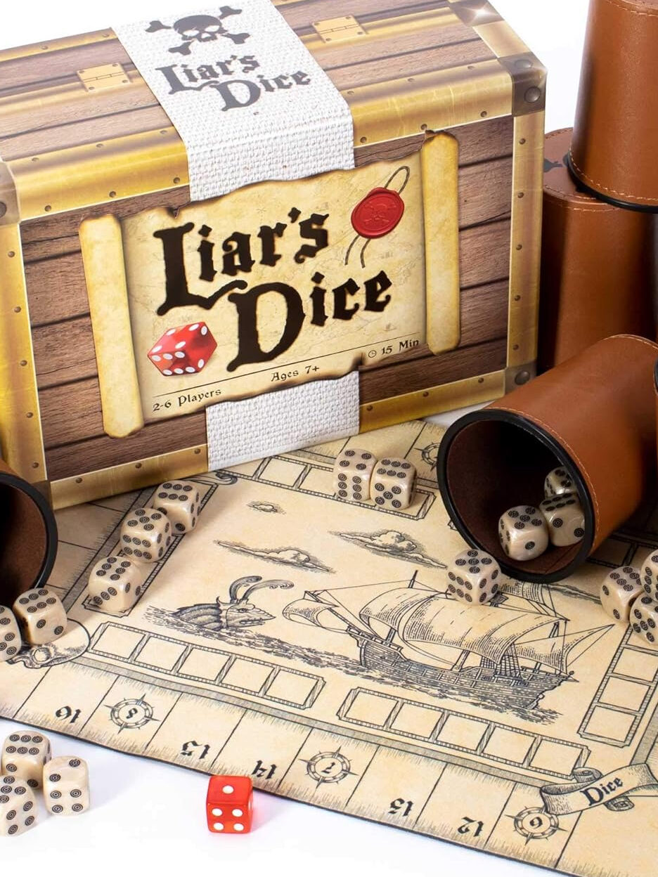 Board game "liar's dice" with dice, cups, and a pirate-themed playing mat.