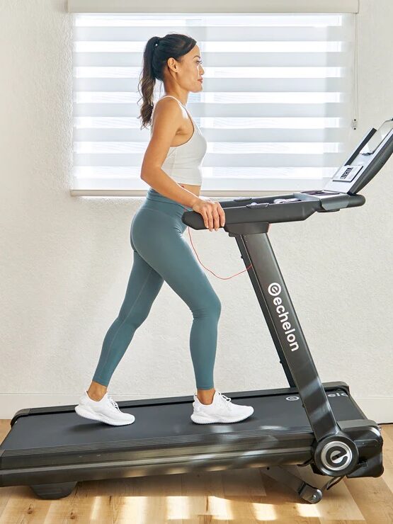 Woman exercising on a treadmill indoors.