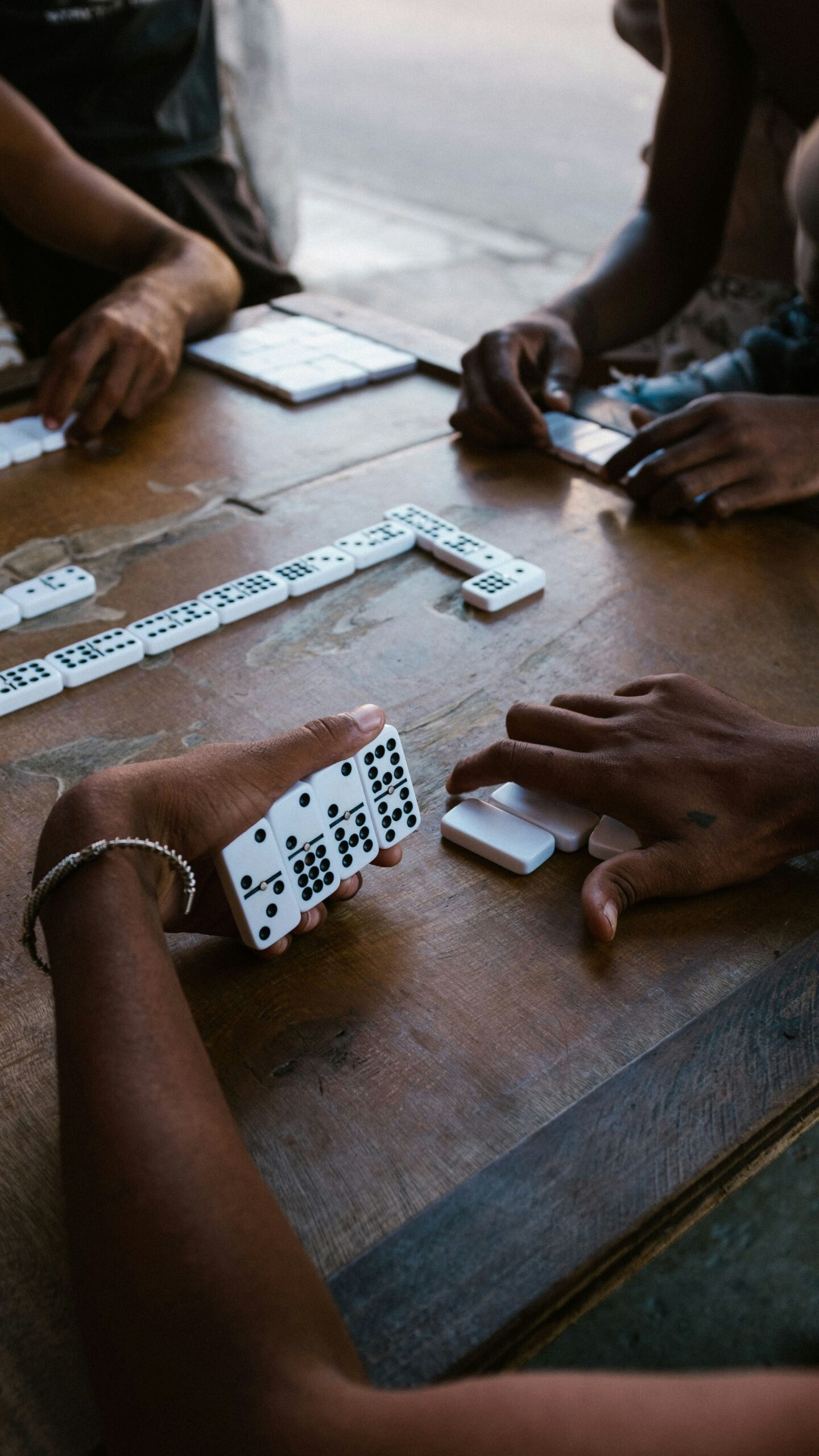 A group of people playing a game of dominoes.