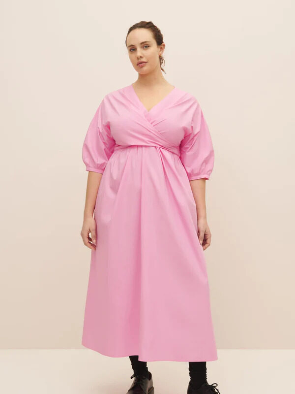 The model is wearing a pink midi dress.