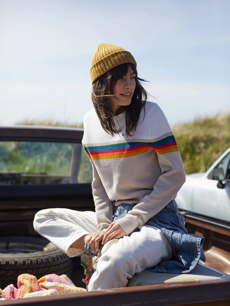 A woman sitting on the hood of a pickup truck.