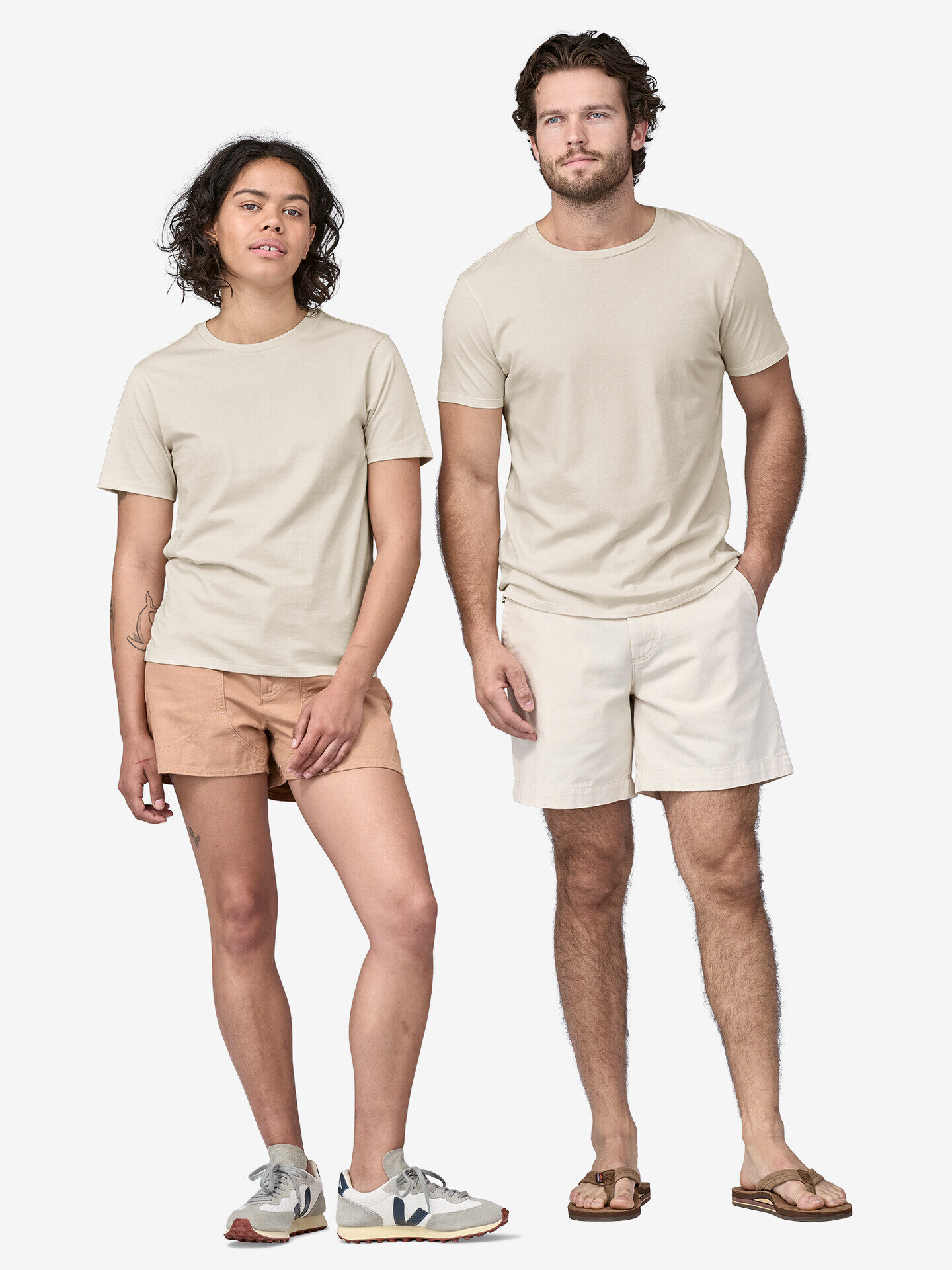 A man and woman wearing beige t - shirts and shorts.