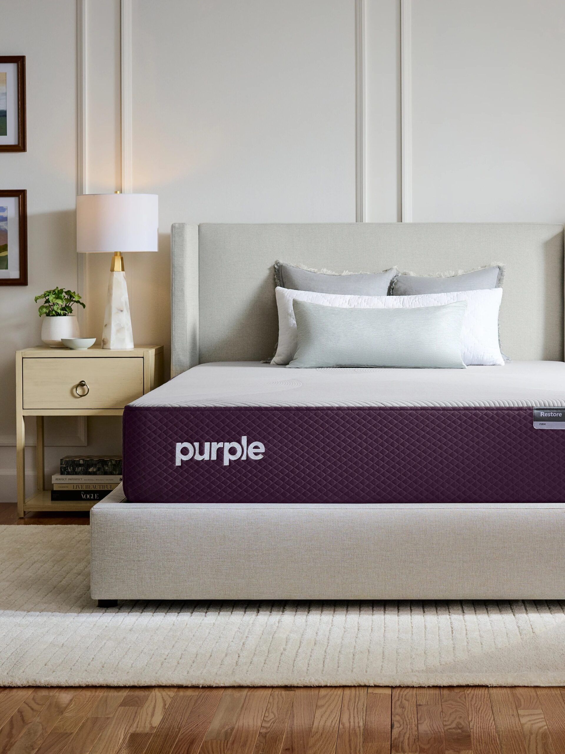 A purple mattress set on a bedframe in a bedroom. 