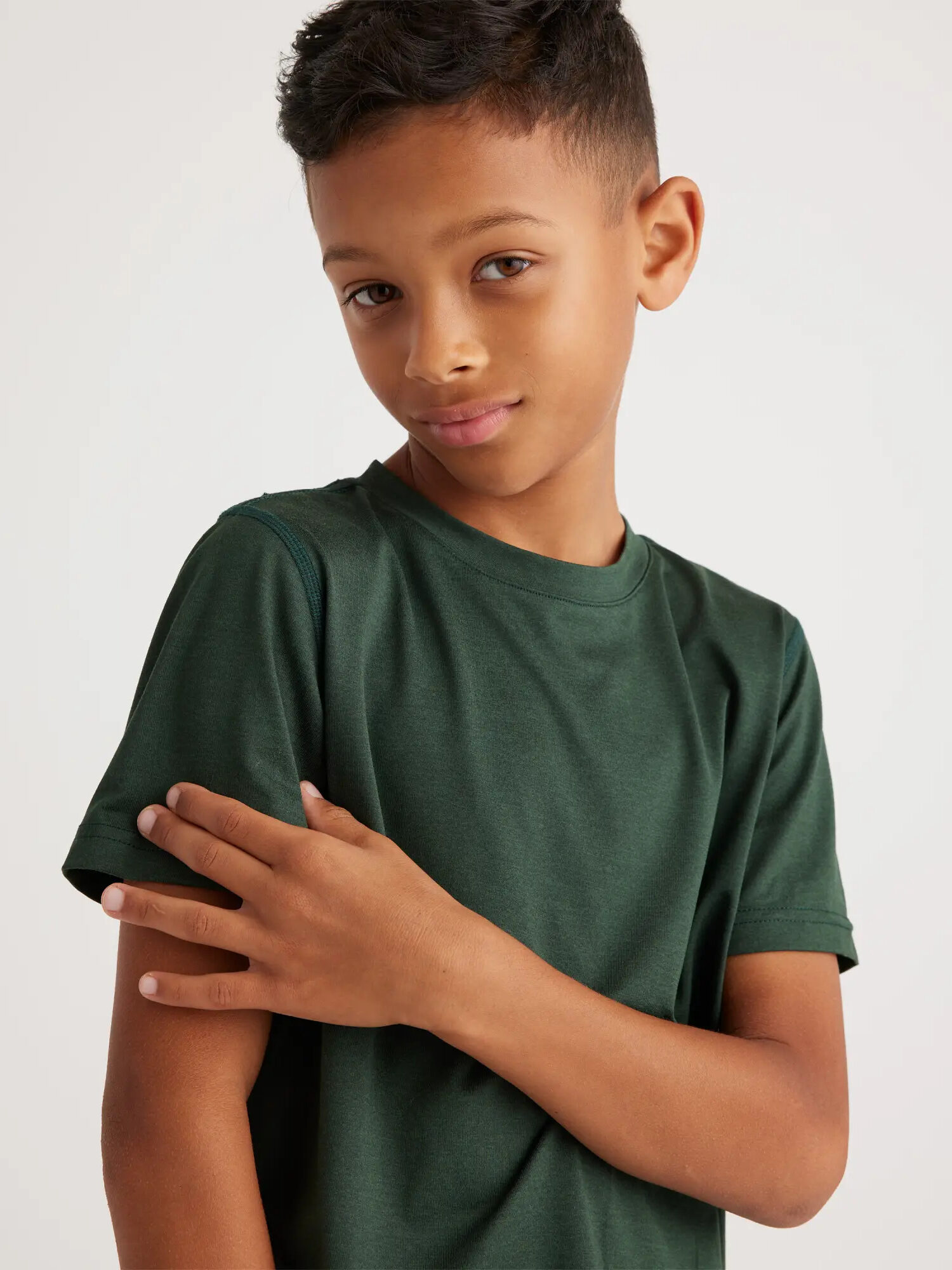 A young boy wearing a green t - shirt.