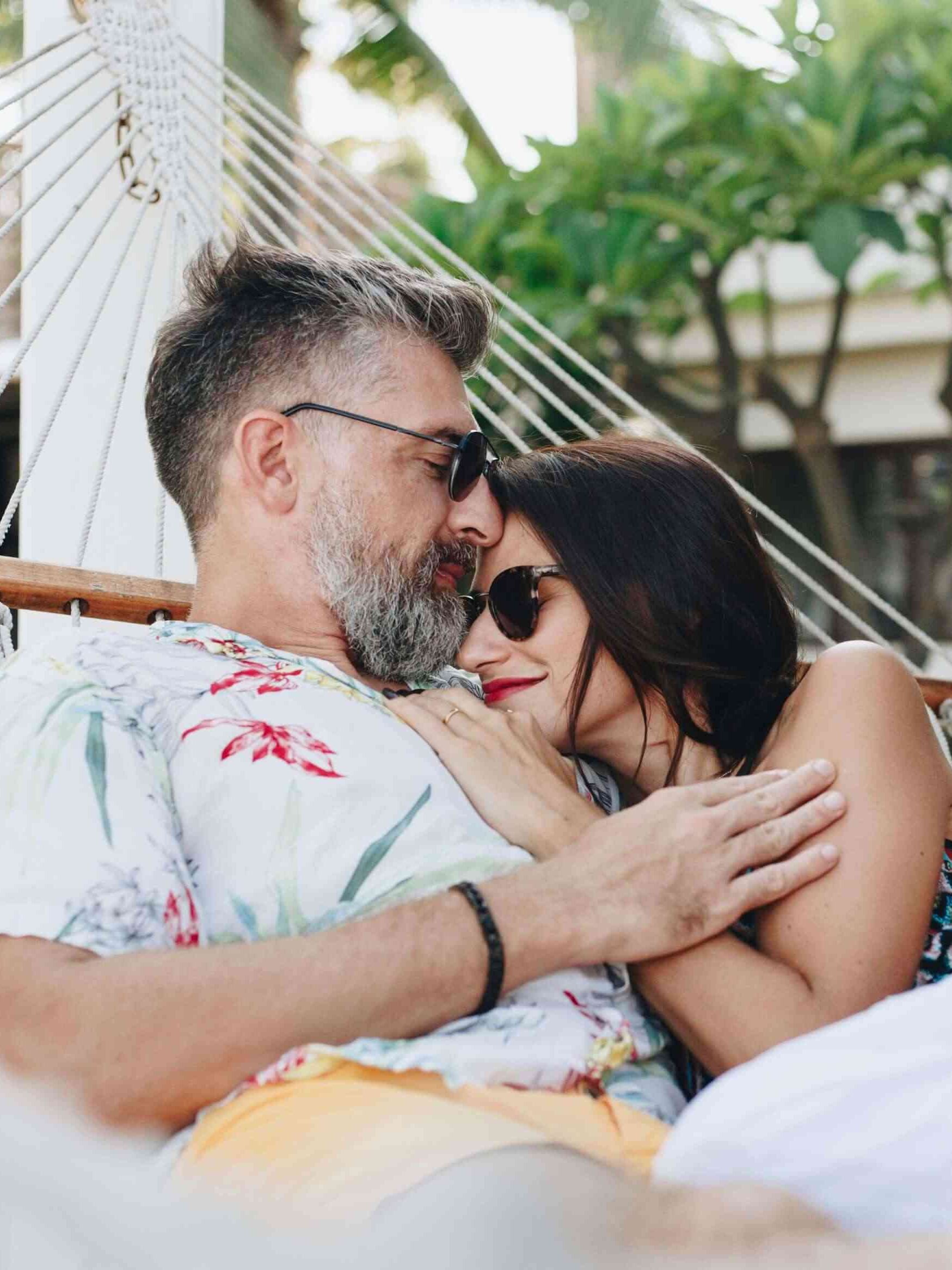 A couple embraces each other on a hammock. 