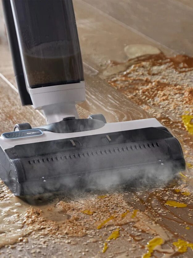Wet-dry vacuum in use cleaning a messy floor.