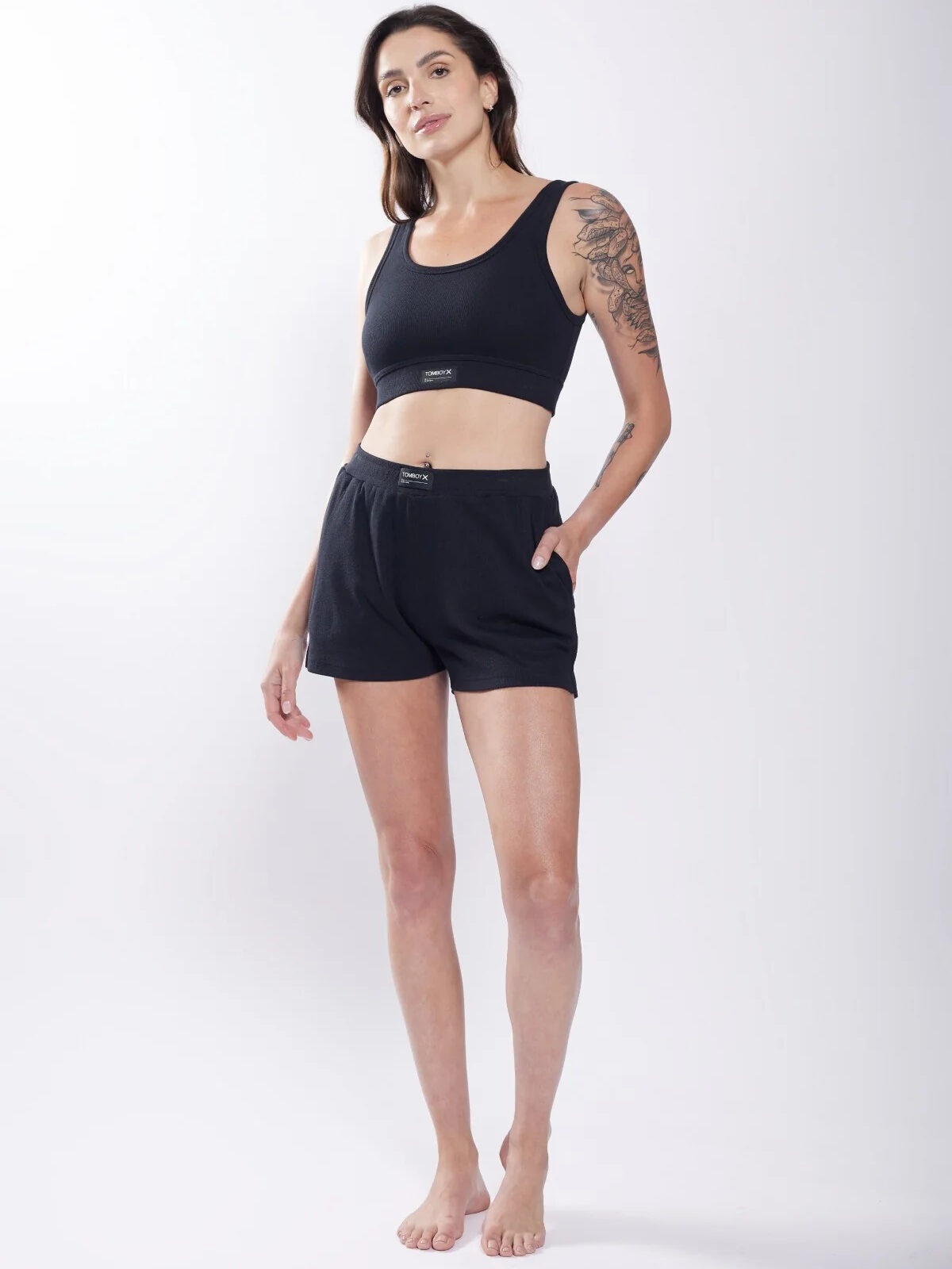 A woman wearing black shorts and a black tank top.