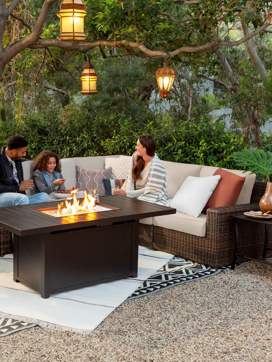 A group of people sitting around a fire pit.