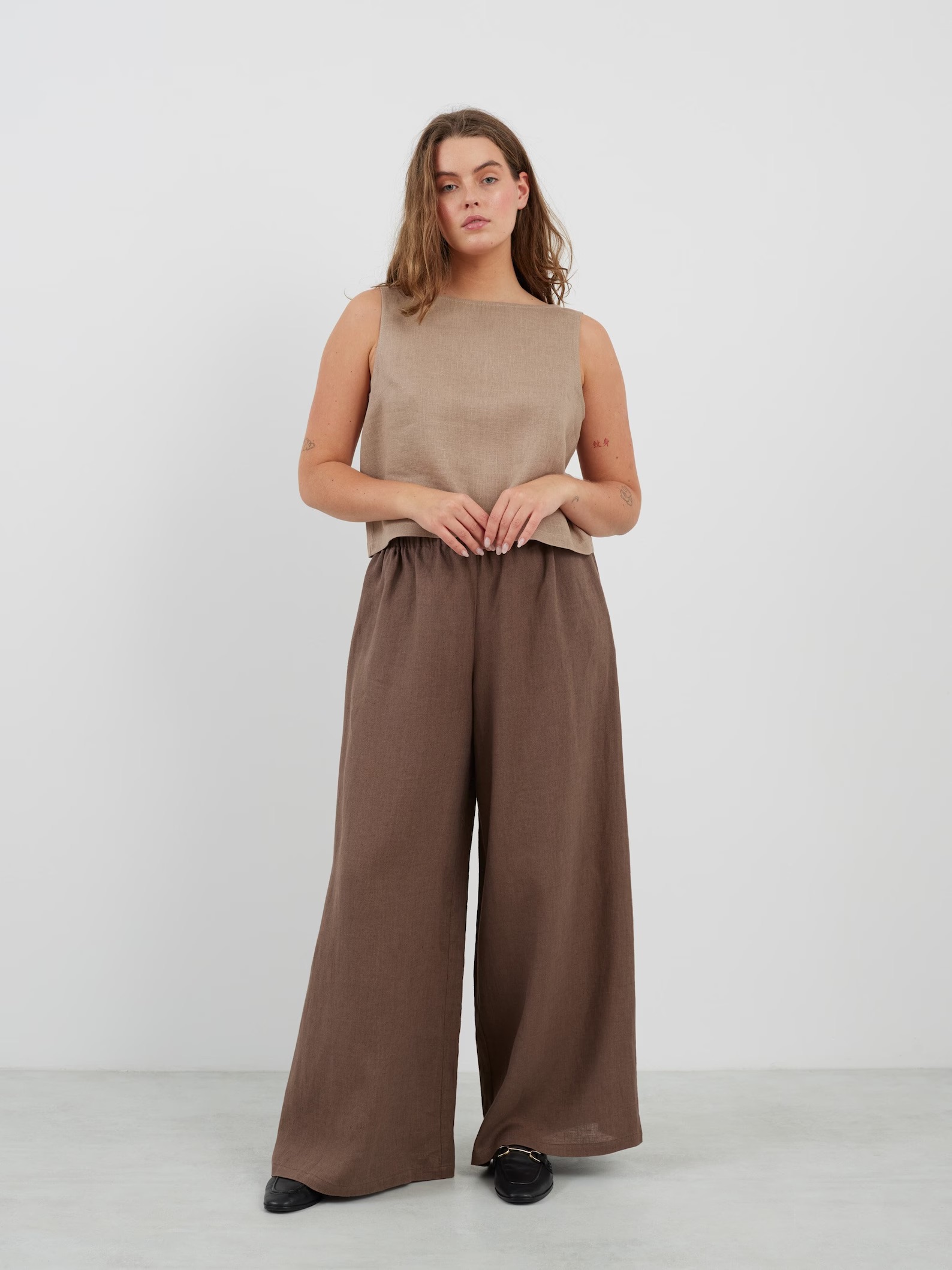 A model wearing a two-tone linen tank and wide leg pants set from Love & Confuse. 