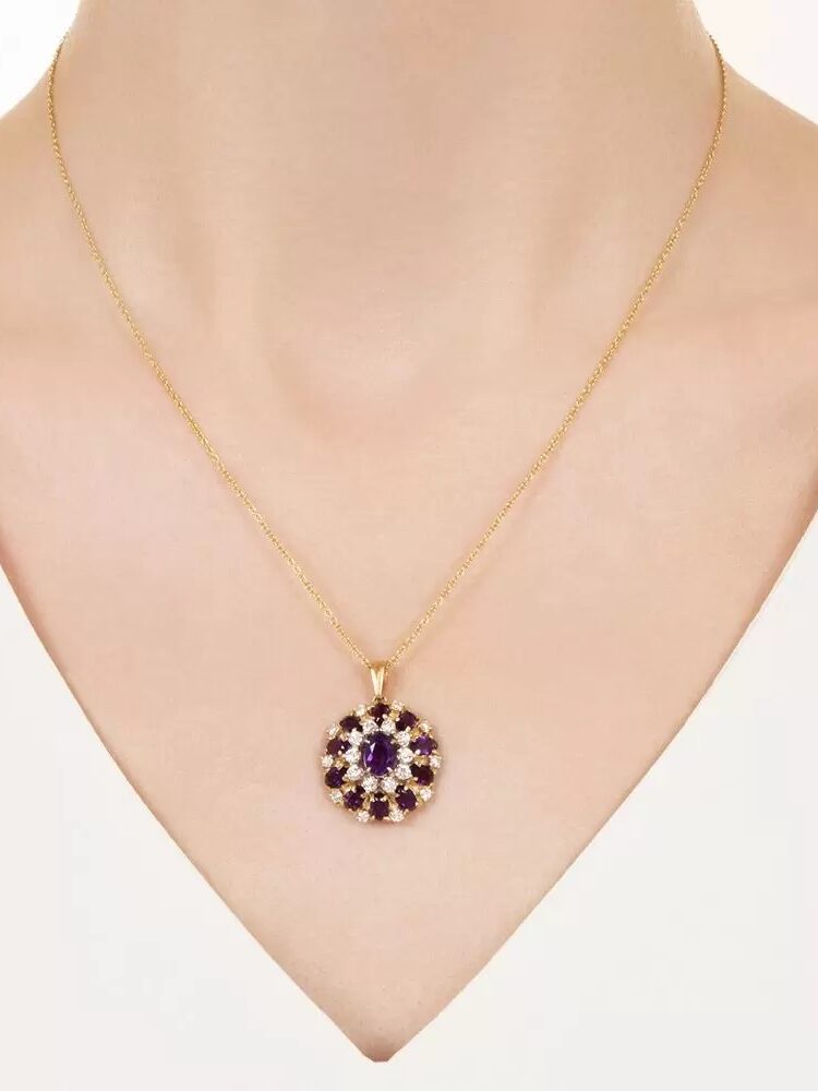 Gold necklace with a circular amethyst pendant on a mannequin's neck.