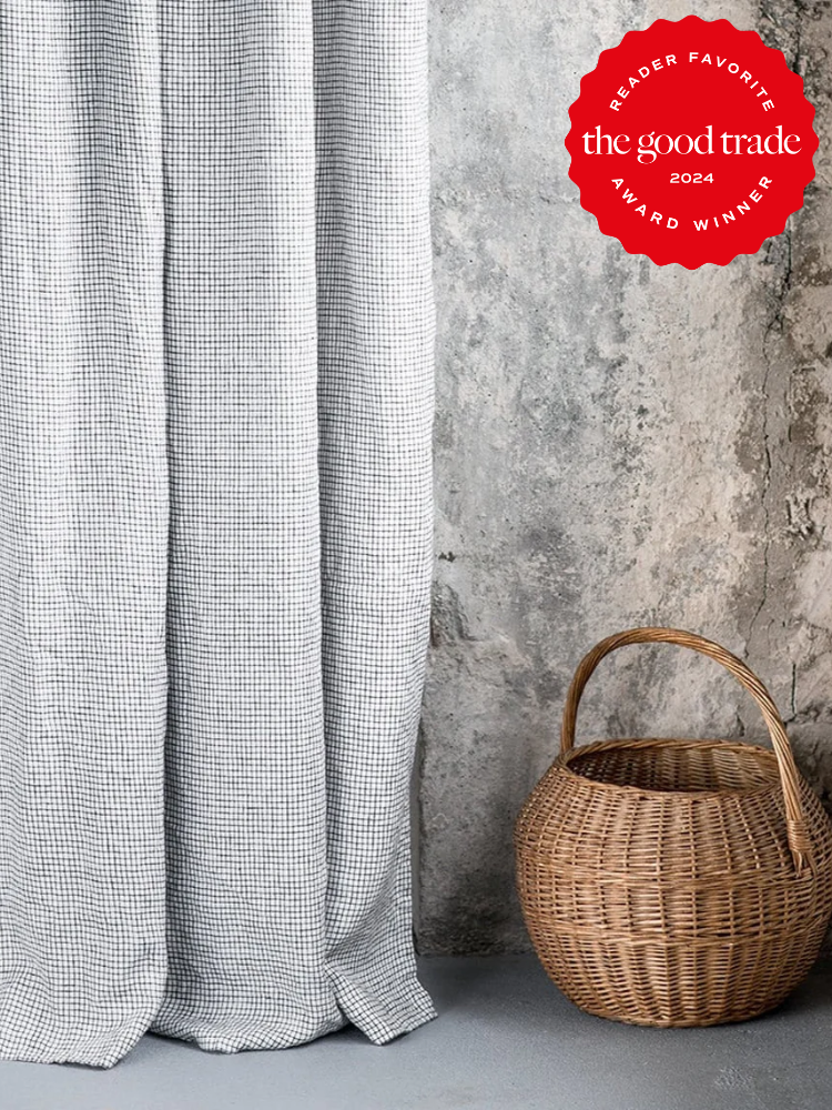Gray houndstooth curtains and a woven basket against a textured concrete wall, featuring a "reader favorite 2024" badge from the good trade.