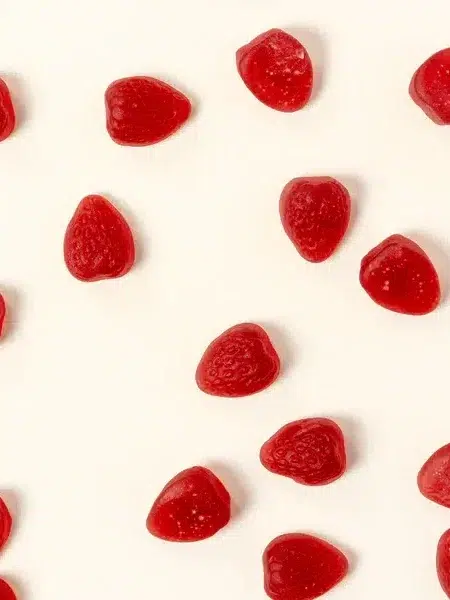 Red heart-shaped candies scattered on a white background.
