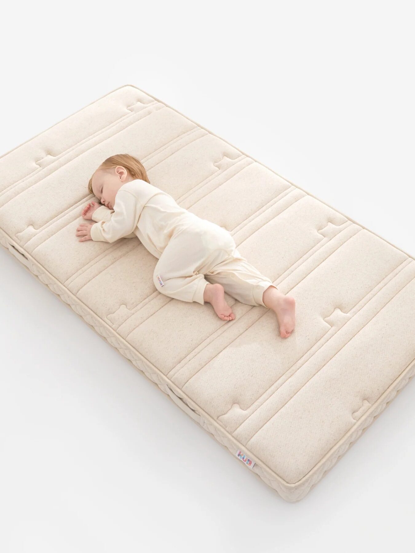 Baby sleeping peacefully on a soft mattress.