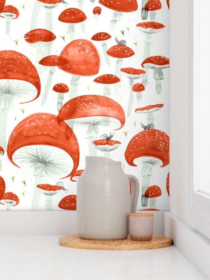 A kitchen corner featuring a ceramic pitcher and cups on a wooden tray against a whimsical red mushroom-patterned wallpaper.