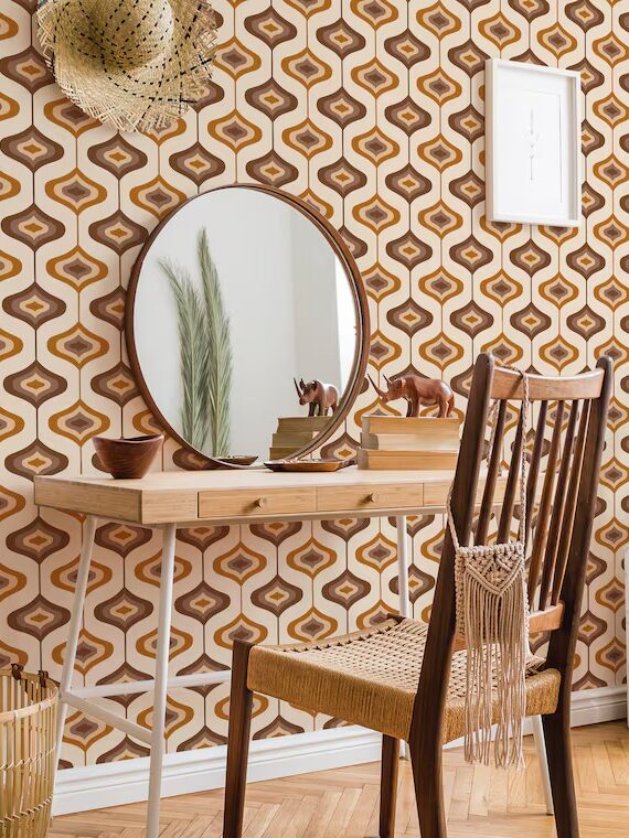 Modern living room with bohemian decor, featuring a patterned wallpaper, round mirror on a wooden desk, and a white sofa.