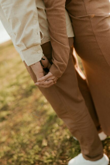 Two people standing side-by-side holding hands.
