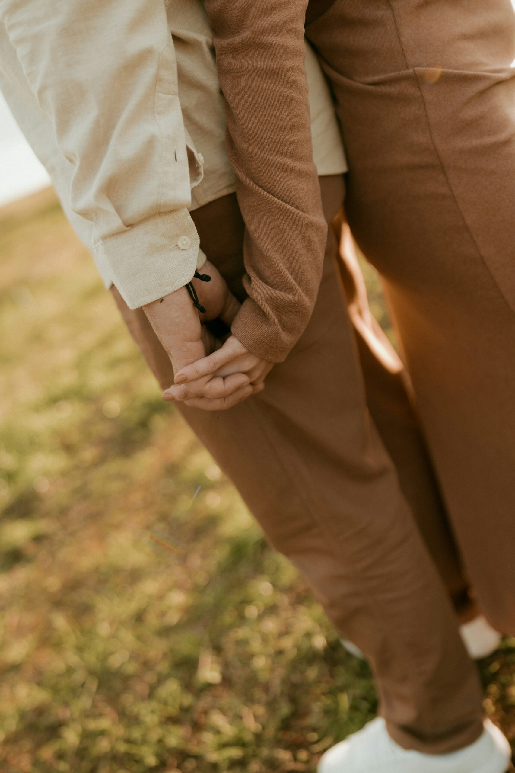 Two people standing side-by-side holding hands.