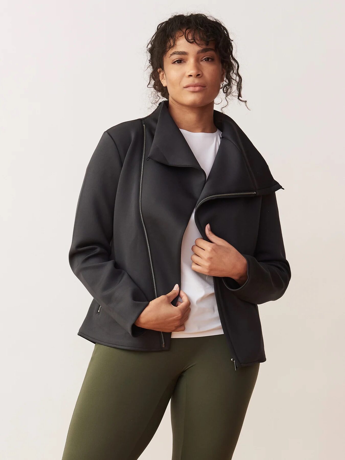 A model wearing a black asymmetrical zipped jacket from Aday. 