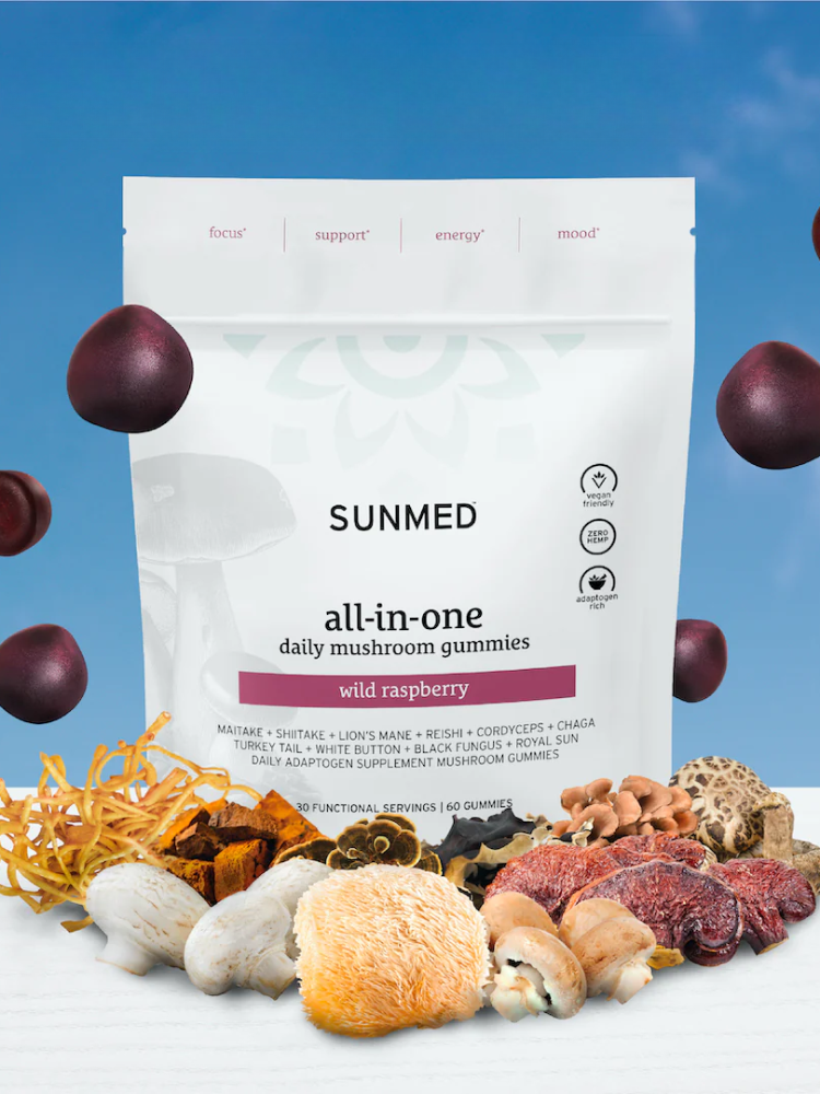 A package of Sunmed all-in-one daily mushroom gummies in wild raspberry flavor is displayed among various whole mushrooms and gummy pieces against a blue background.