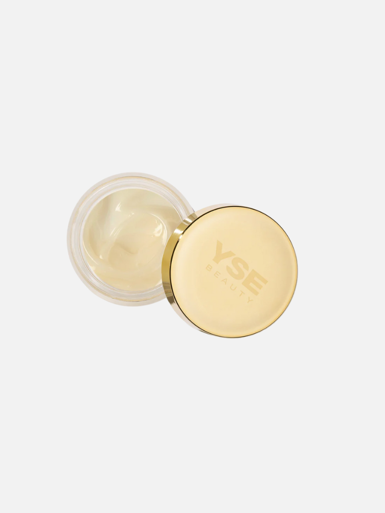 An open jar of cream with a gold lid labeled "YSE Beauty," viewed from above against a white background.