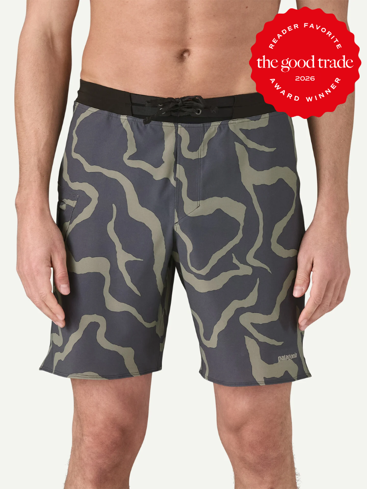 A person wearing gray and olive green patterned board shorts with a black waistband; a red award badge appears in the top right corner.