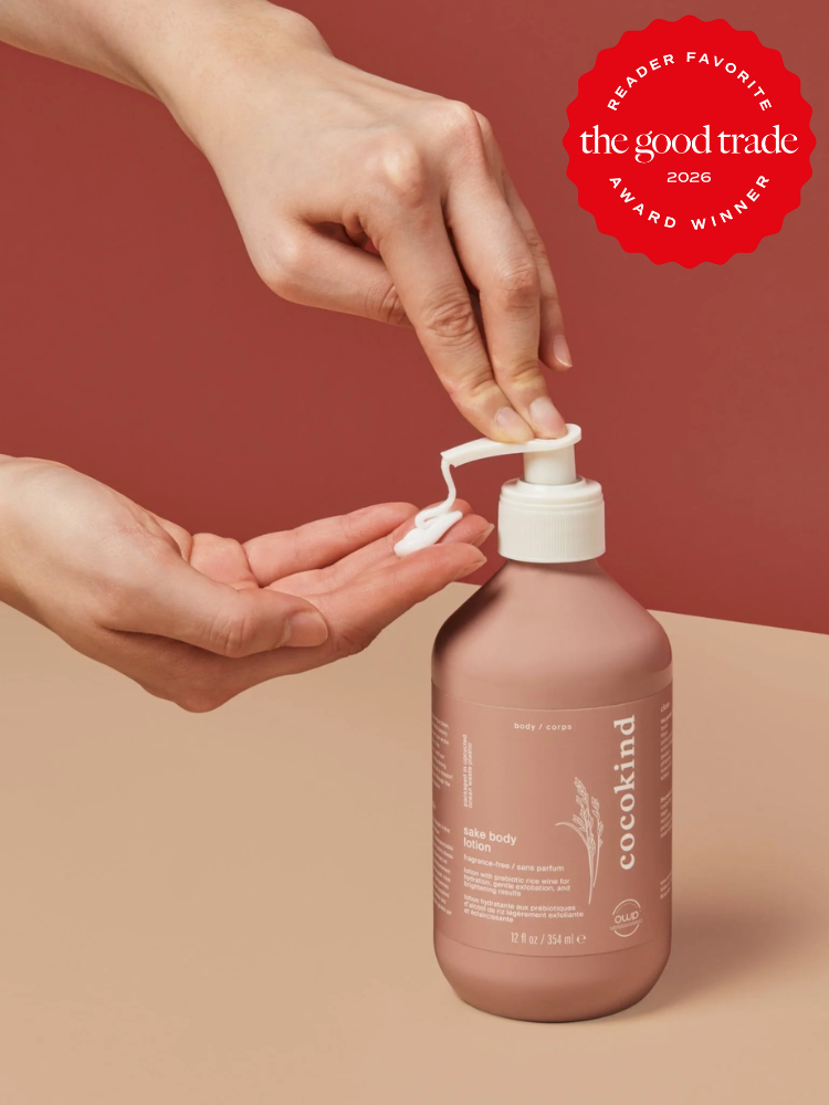 A person pumps lotion from a pink Cocokind bottle onto their hand. A red "The Good Trade Reader Favorite 2026 Award Winner" badge appears in the top right corner.
