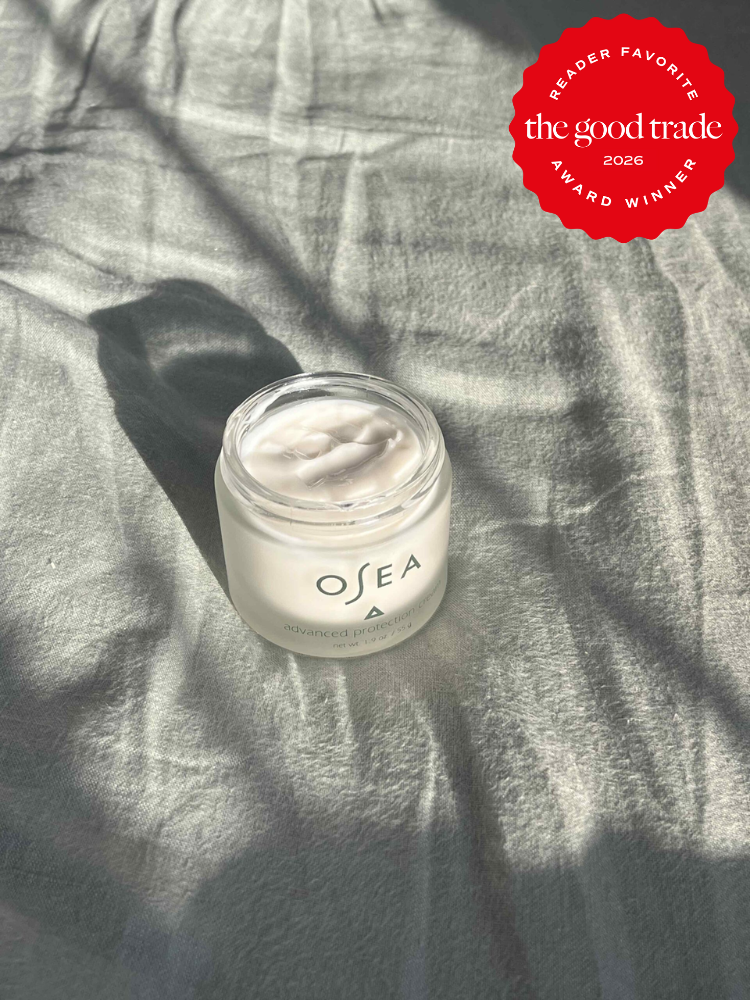 A jar of OSEA advanced protection cream sits on a wrinkled light gray fabric with a "The Good Trade Reader Favorite 2026 Award Winner" badge in the corner.