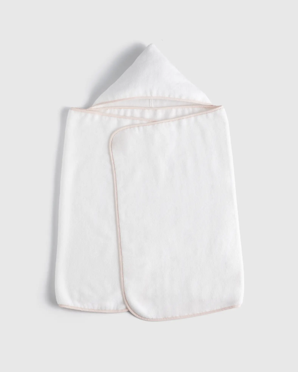 White hooded baby towel with a pointed hood and rounded corner, trimmed with light pink edging, laid flat on a plain light grey background.