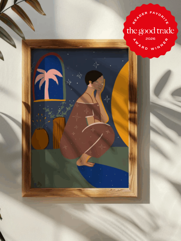 A framed abstract artwork of a seated person in a star-patterned dress, with a window, plants, and moon in the background, hangs on a wall. A red award badge is in the top right corner.