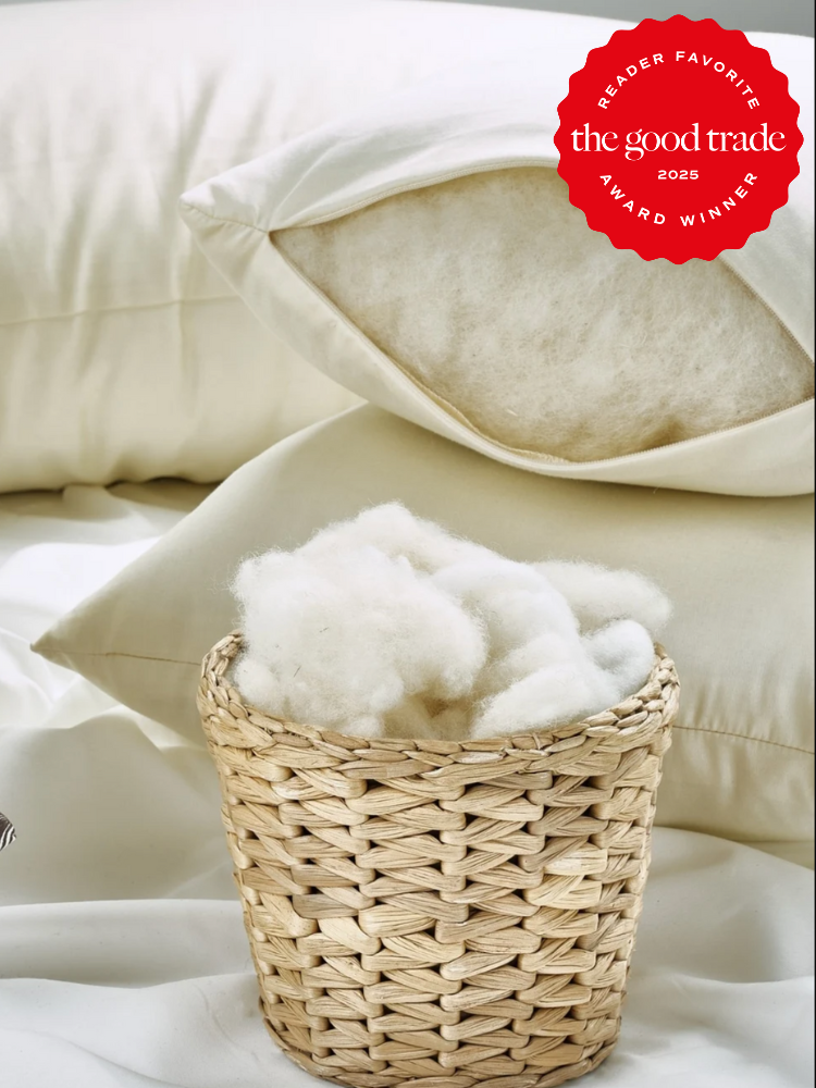 Two white pillows rest on a bed beside a small wicker basket filled with cotton; a red badge in the corner reads “Reader Favorite, The Good Trade, 2025 Award Winner.”.