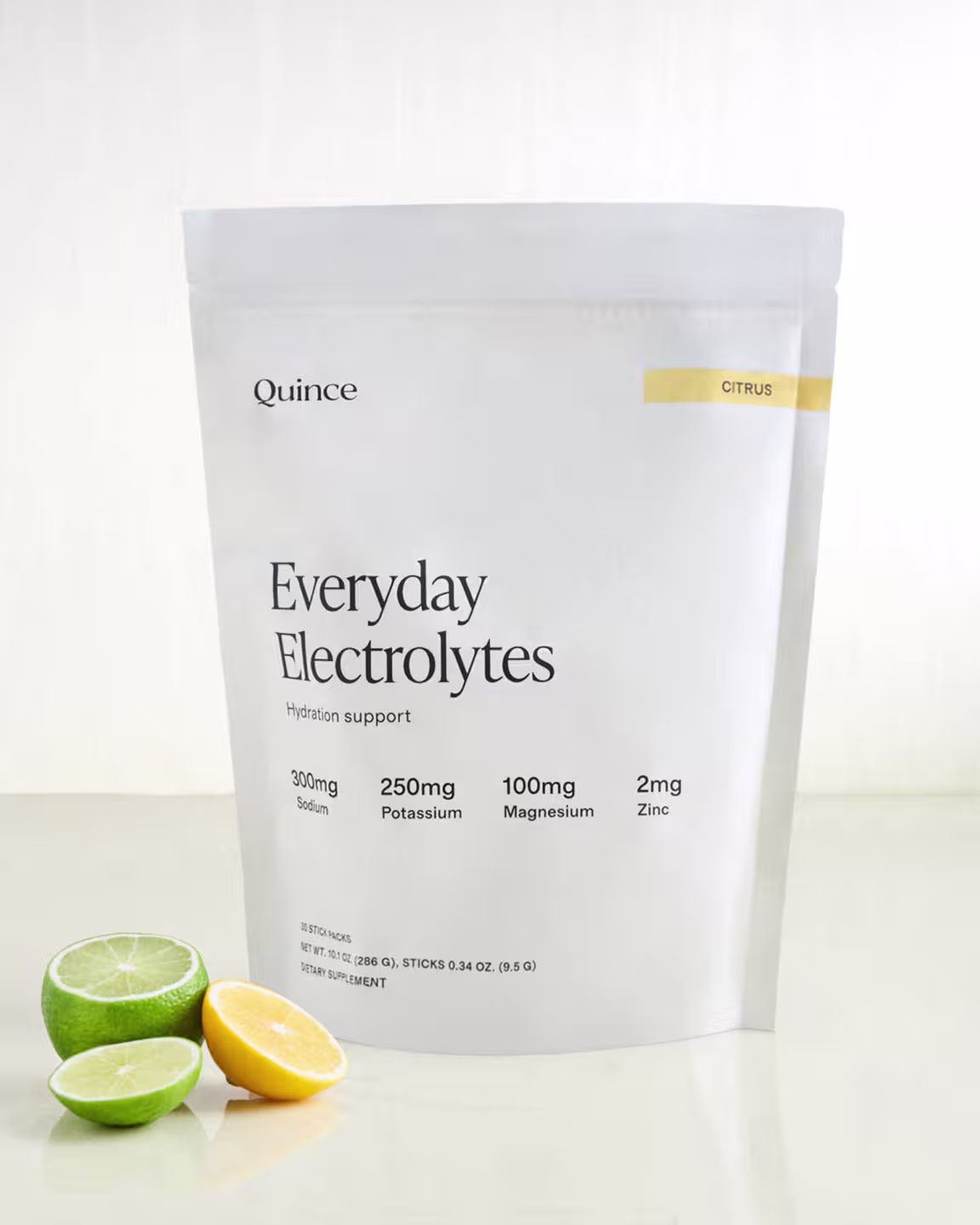 A white pouch labeled "Quince Everyday Electrolytes" with citrus fruits beside it; supplement facts for sodium, potassium, magnesium, and zinc are printed on the front.