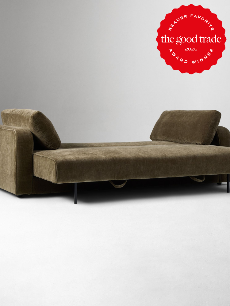 Olive green velvet sofa with two back cushions and black metal legs, pictured on a light background. A red "The Good Trade 2026 Award Winner" badge is in the top right corner.