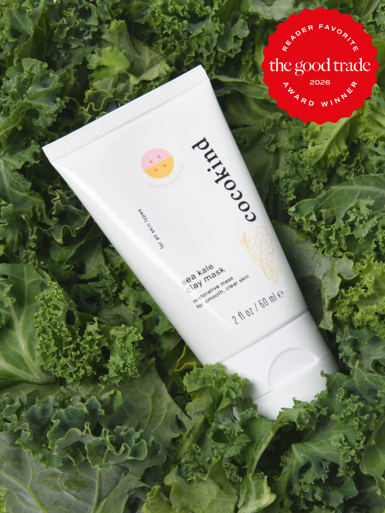 A tube of Cocokind sea kale clay mask rests on fresh kale leaves. The image features a red "The Good Trade 2026 Reader Favorite Award Winner" badge in the top right corner.