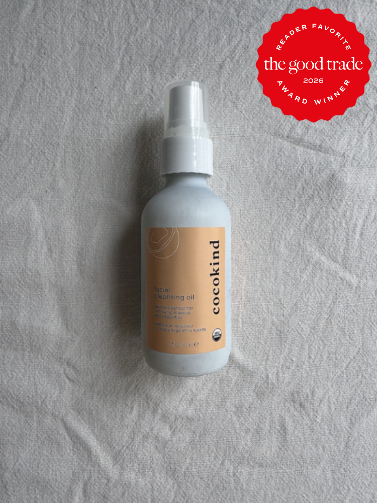 A bottle of Cocokind facial cleansing oil is placed on a textured light fabric. A red badge in the top right corner reads "The Good Trade Reader Favorite Award Winner 2026.