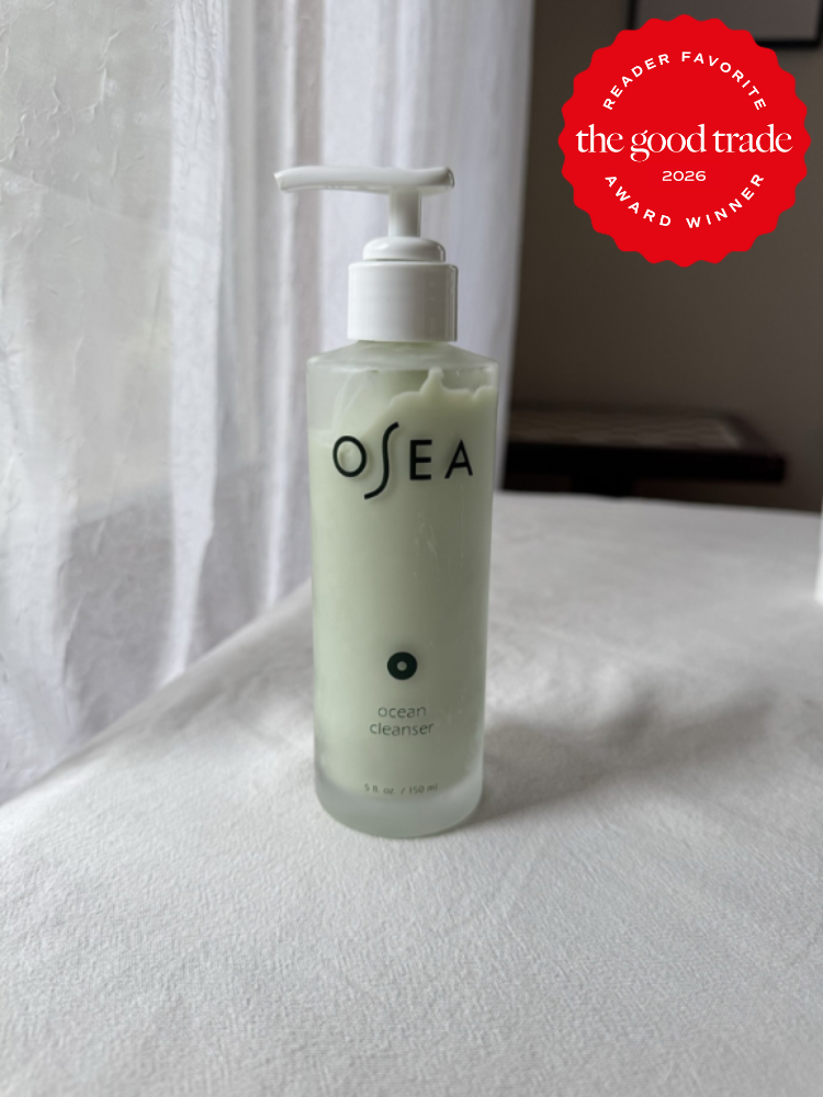 A bottle of OSEA Ocean Cleanser with a pump sits on a white surface near a window; a red badge in the corner reads "The Good Trade Award Winner 2026.