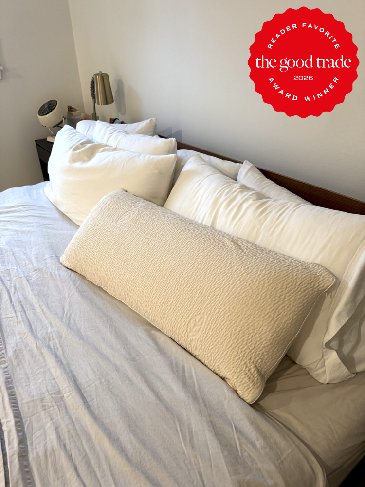 A neatly made bed with white linens and several pillows; a red "Reader Favorite – The Good Trade 2026 Award Winner" badge is in the top right corner.