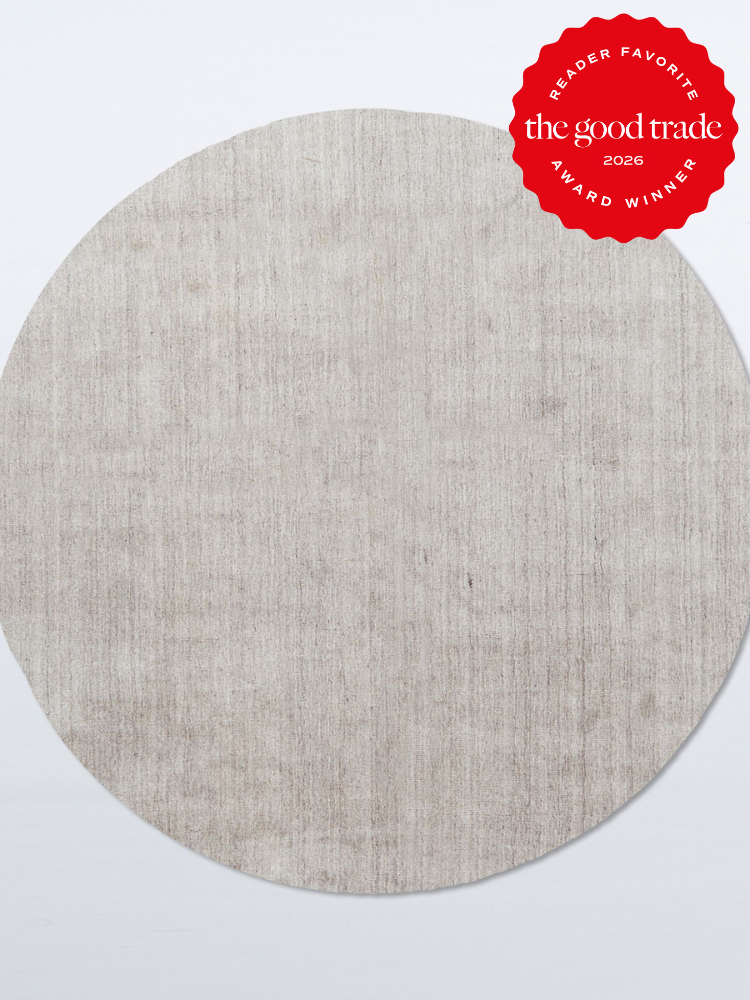 A round, light gray textured rug on a plain background with a red "The Good Trade 2026 Award Winner" badge in the top right corner.