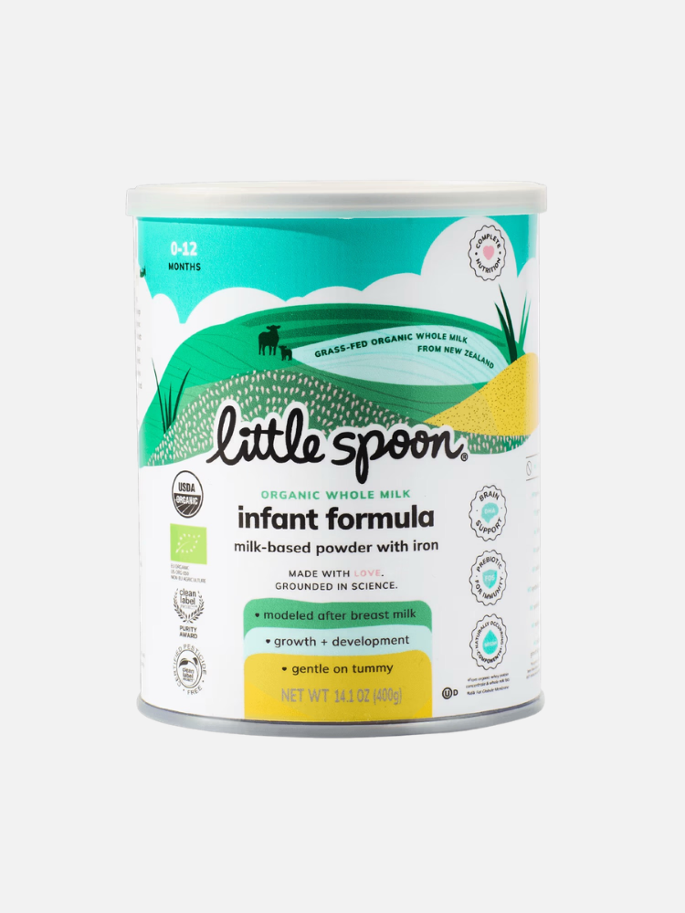 A canister of Little Spoon organic whole milk infant formula, labeled for ages 0-12 months, featuring green, white, and yellow design elements.