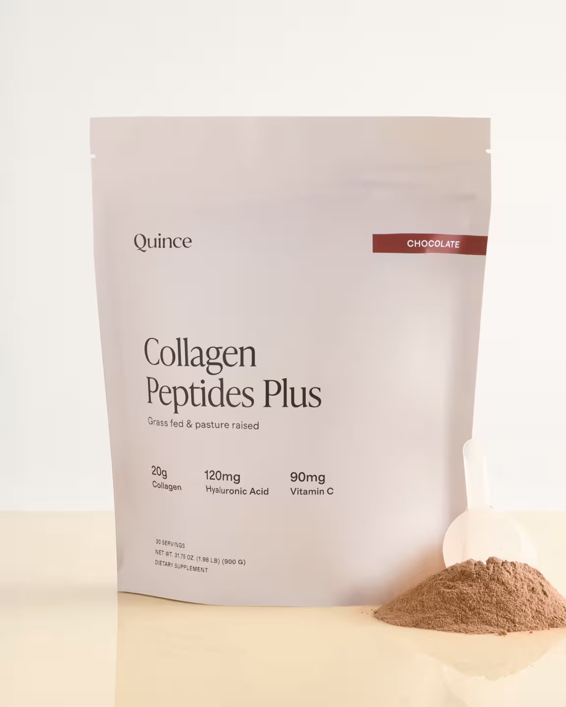 A bag of Quince Collagen Peptides Plus chocolate powder with a clear scoop of powder beside it on a light surface.