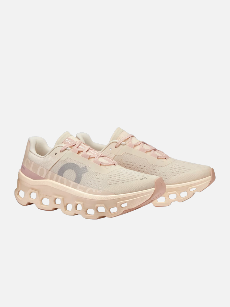 A pair of beige and light pink athletic sneakers with ventilated uppers and unique hollowed soles, displayed on a white background.