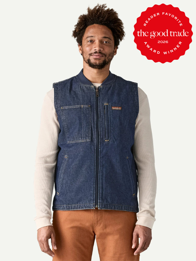 A man wearing a denim zip-up vest over a light long-sleeve shirt and brown pants stands facing forward. A red "The Good Trade Reader Favorite Award Winner 2026" badge is in the top right corner.