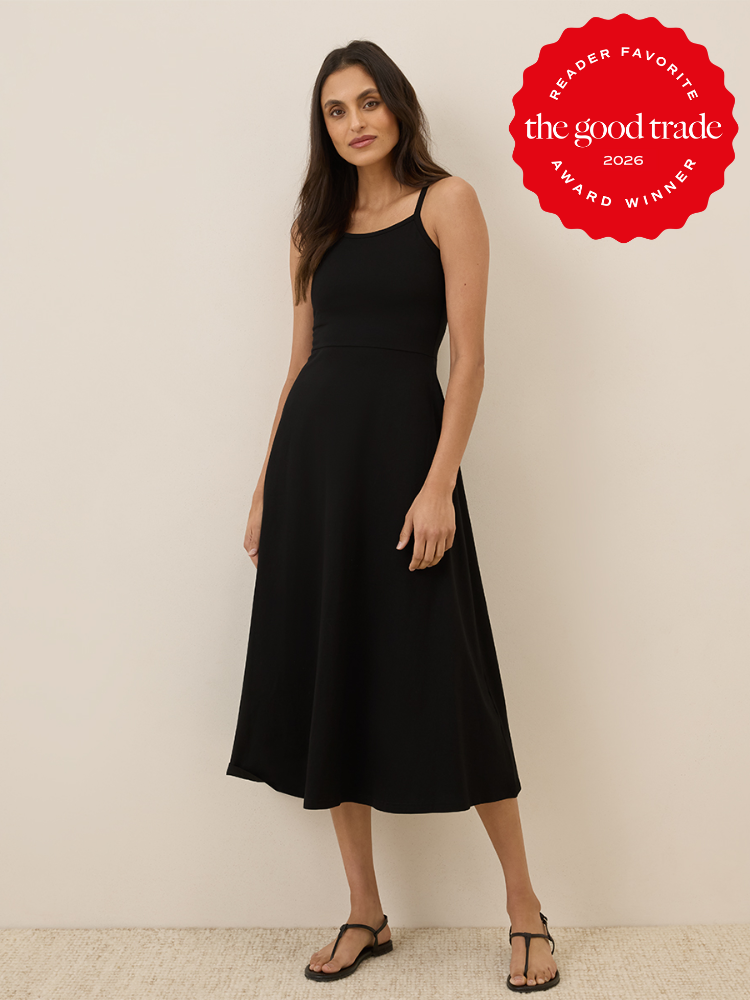 A woman wearing a sleeveless black midi dress and black sandals stands against a plain background. A red badge in the corner reads, "The Good Trade Award Winner 2026.