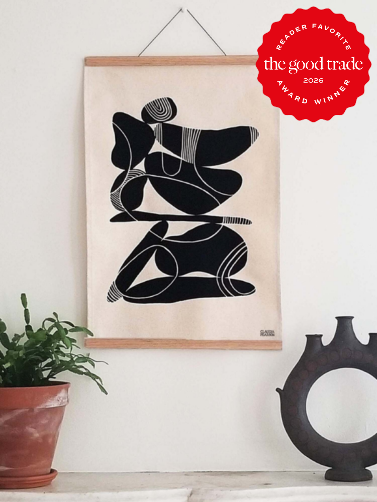 Abstract black and white wall art hangs above a table with a potted plant and a decorative object; a red "The Good Trade 2026 Award Winner" badge appears in the upper right.