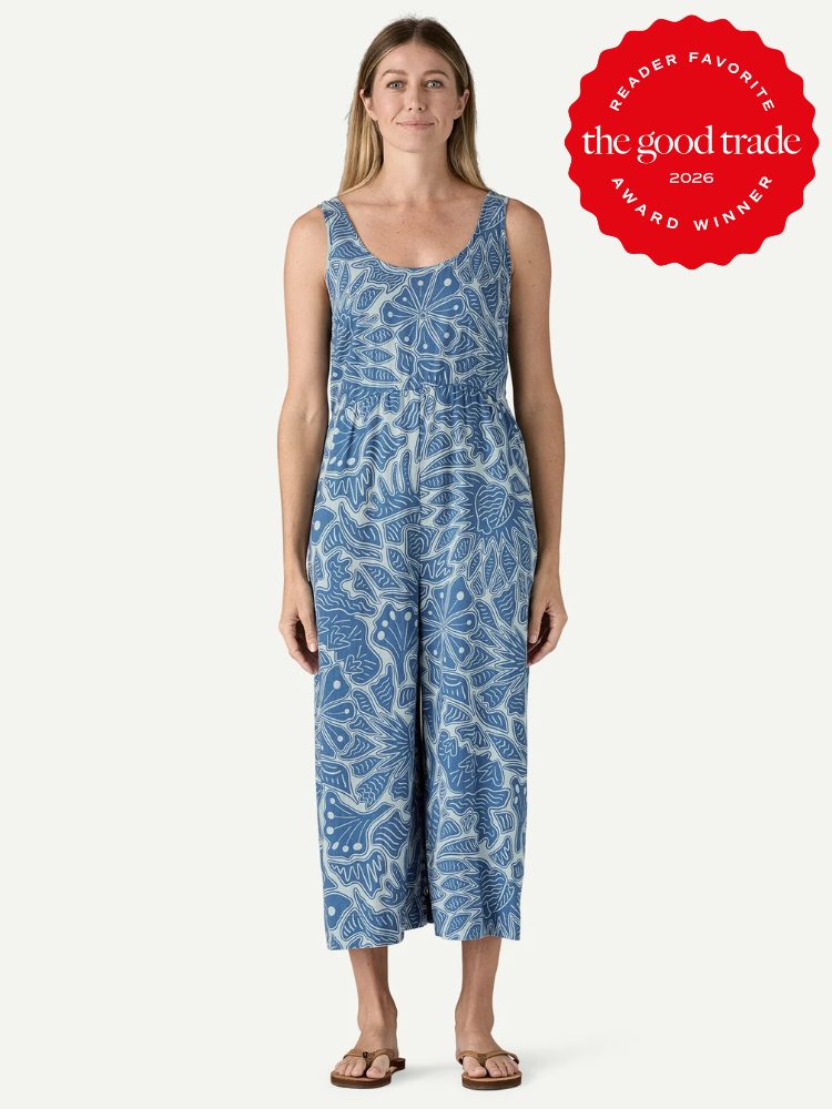 Woman wearing a blue and white patterned sleeveless jumpsuit, standing and facing forward. "The Good Trade 2026 Reader Favorite Award Winner" badge is in the top right corner.